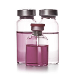 three glass vials containing colored liquids