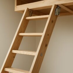 Close-up of a wooden loft ladder leading to an attic space.